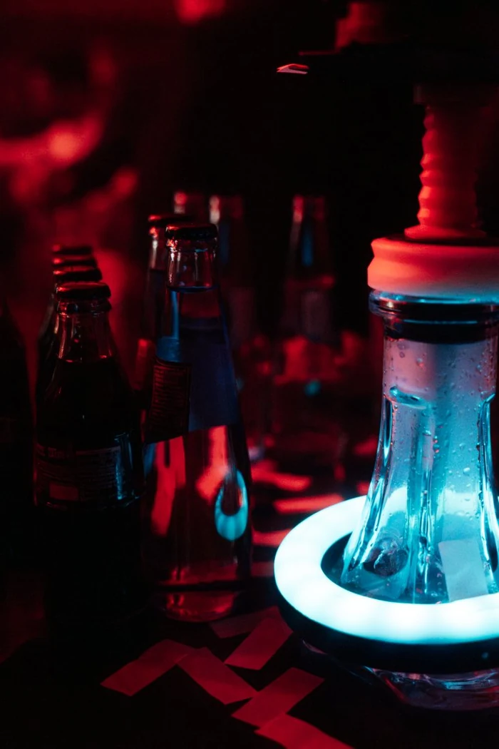 Refrescos y una cubitera iluminada sobre la mesa de un reservado, con la sala en rojo